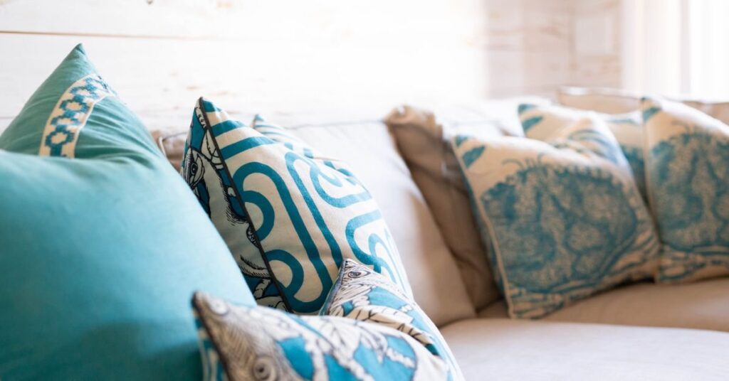 A cozy couch adorned with blue and white decorative pillows, creating a stylish and inviting living space.