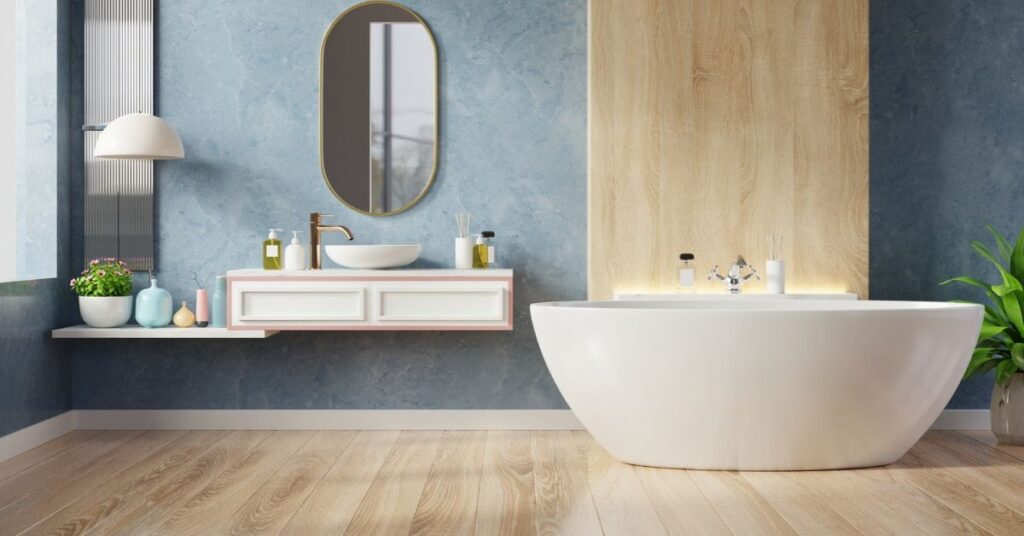 A blue bathroom featuring a white bathtub and a warm wooden floor, creating a serene and inviting atmosphere.