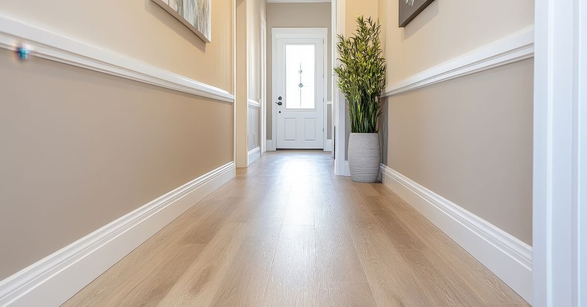 A hallway featuring a white door and a wall-mounted plant, creating a fresh and inviting atmosphere.