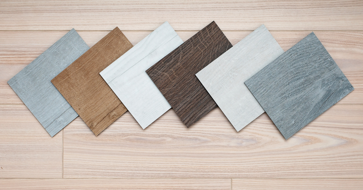 A collection of hardwood & luxury vinyl flooring samples showcasing various types and finishes arranged neatly on a display surface.