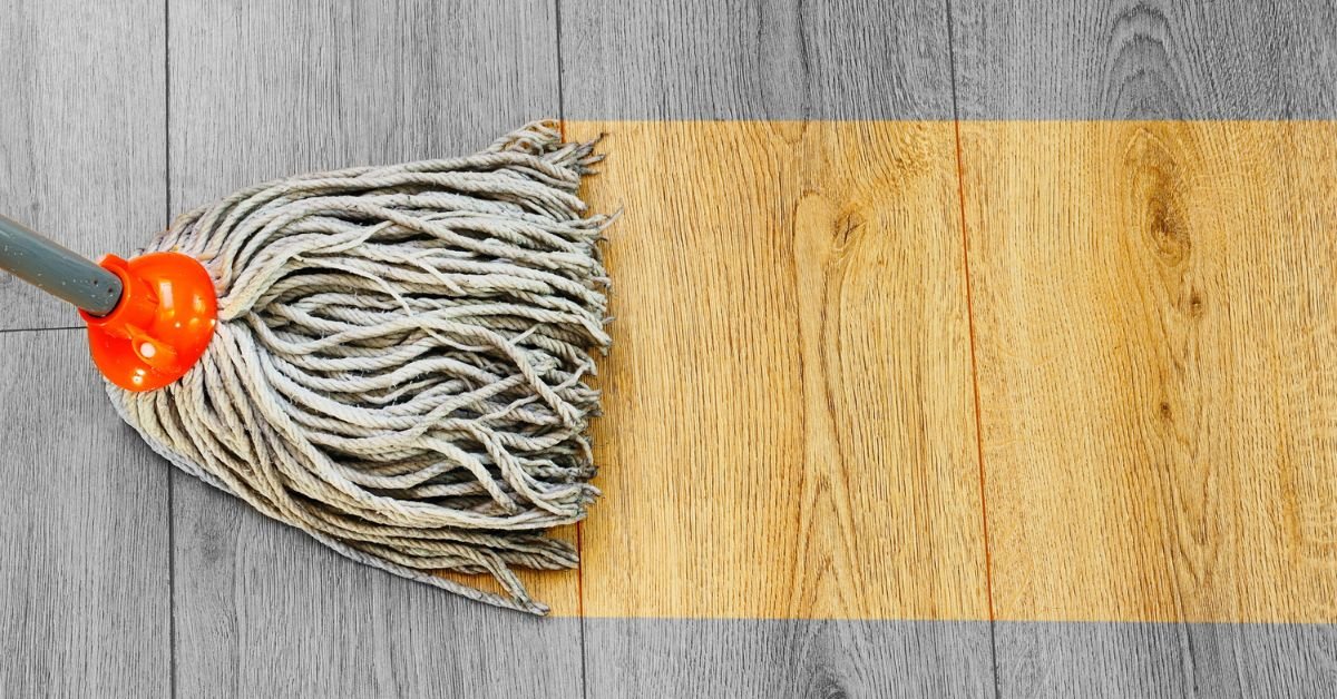 A mop resting on a wooden floor, with a distinct yellow line marking the surface.