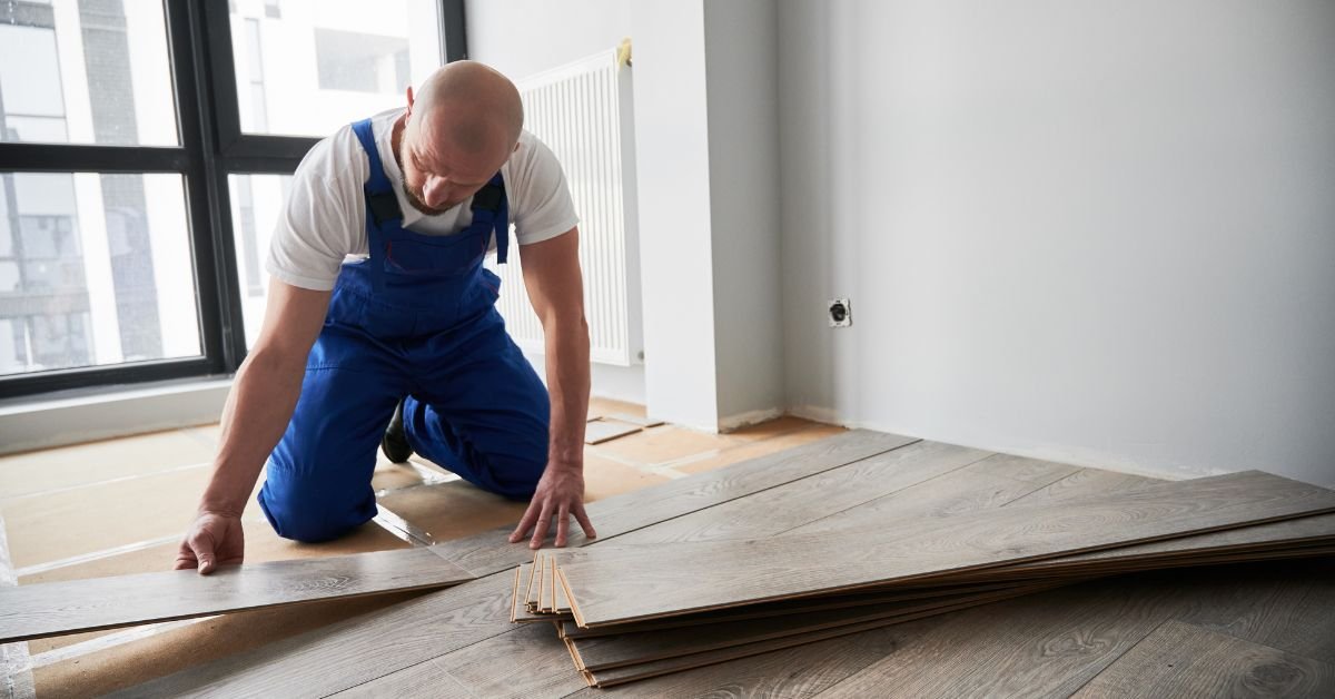 Man Installing Laminate Timber Floor in Apartment under Renovation