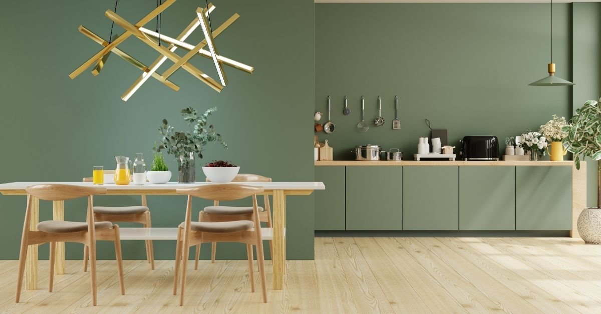 A cozy green kitchen with wooden flooring and a dining table, perfect for family meals and gatherings.