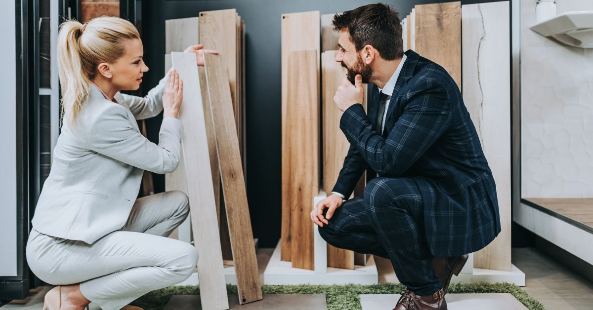 A man and woman dressed in business attire are inspecting a wooden material, engaged in a professional discussion.
