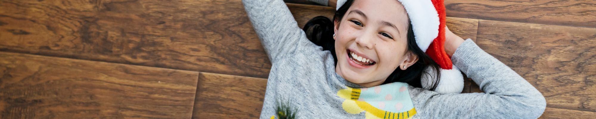 child laying on floor in santa hat